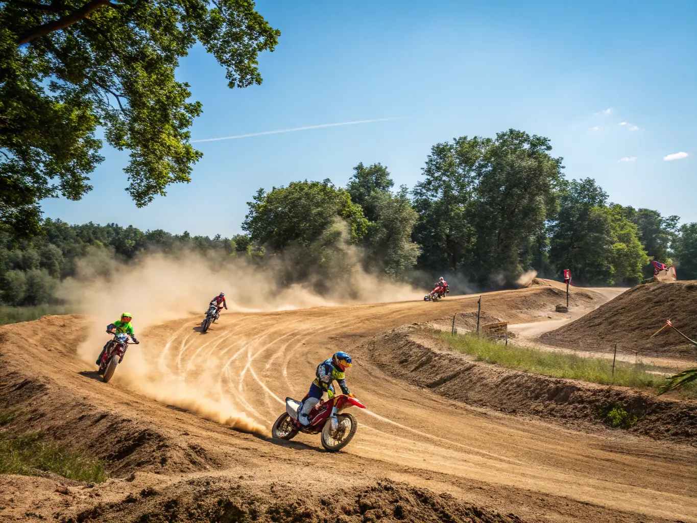 An action-packed image of a motocross event, featuring riders competing on a dirt track with jumps and turns, showcasing the speed and excitement of the sport.
